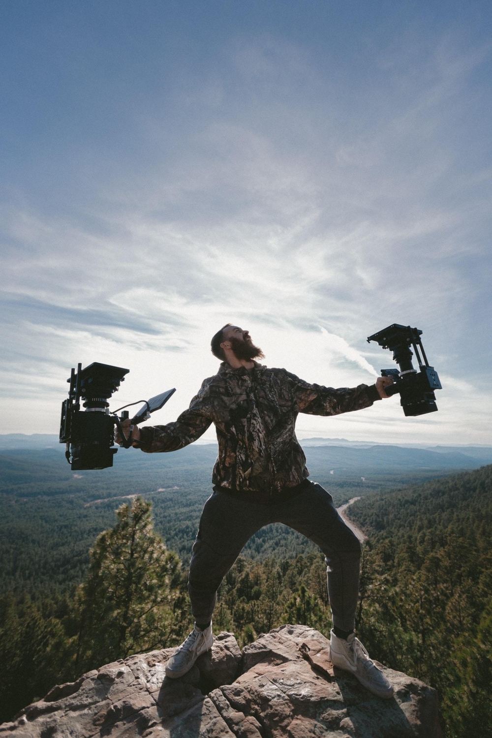 man op berg met camera